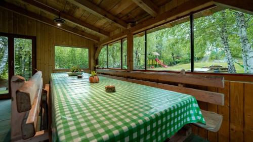 Habitación con mesa y mantel blanco y verde a cuadros. en Robinzonski smještaj "Lazac Lokvarski" Lokve, en Lokve