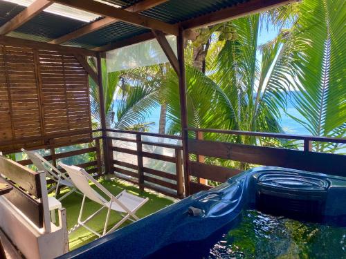 une maison avec un bain à remous, des chaises et des palmiers dans l'établissement Les îlots du soleil levant, à Saint-André