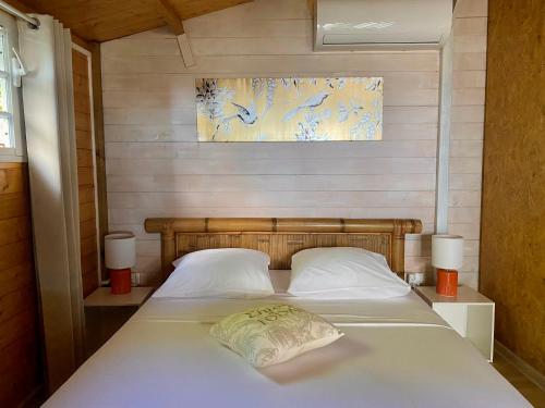 1 dormitorio con 1 cama con 2 almohadas blancas en Les îlots du soleil levant en Saint-André