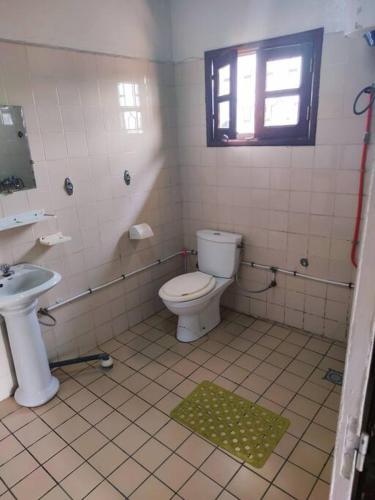a bathroom with a toilet and a sink at Bel Appartement meublé à Bastos in Yaoundé