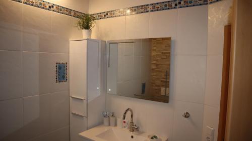 W białej łazience znajduje się umywalka i lustro. w obiekcie Toskana w mieście Klingenmünster