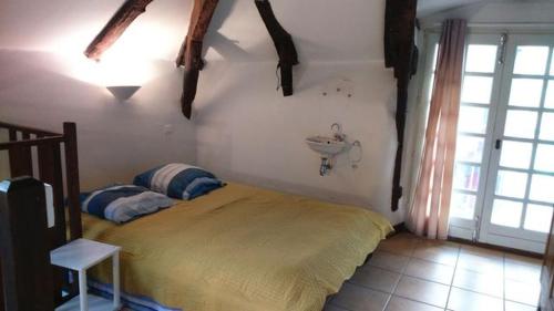 - une chambre avec un lit et un lavabo sur le mur dans l'établissement Maison Antraigues sur Volane, à Asperjoc