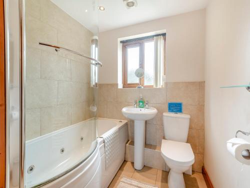 a bathroom with a tub and a sink and a toilet at The Old Dairy in Clay Cross