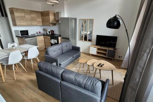 un salon avec un canapé et une table dans l'établissement Bel Appart' 3 chambres 3 Sdb au centre-ville St Etienne, à Saint-Étienne