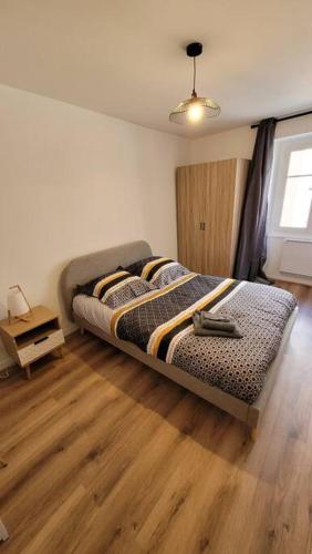 une chambre avec un lit et un parquet dans l'établissement Bel Appart' 3 chambres 3 Sdb au centre-ville St Etienne, à Saint-Étienne