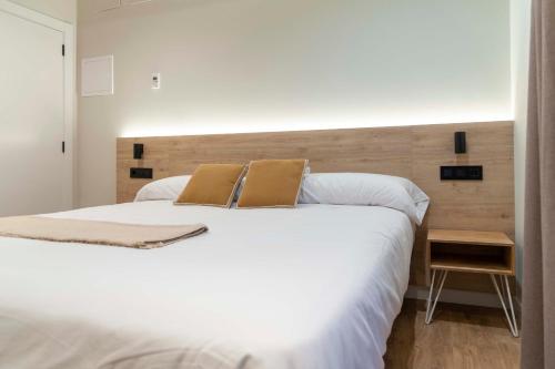um quarto com uma grande cama branca e 2 almofadas em Albatros em Puentedeume