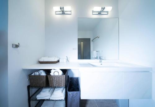 La salle de bains blanche est pourvue d'un lavabo et d'un miroir. dans l'établissement Mae Phim Grand Blue Condo 508 with pool and seaview, à Mae Pim