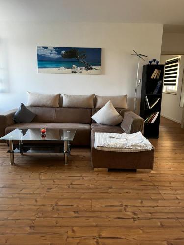 a living room with a brown couch and a table at Ferienwohnung Coburger Land, ländlich gut gelegen in Meeder