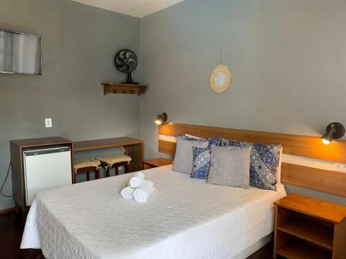 a bedroom with a bed with a white flower on it at Pousada do Grilo in Santo Antônio do Pinhal