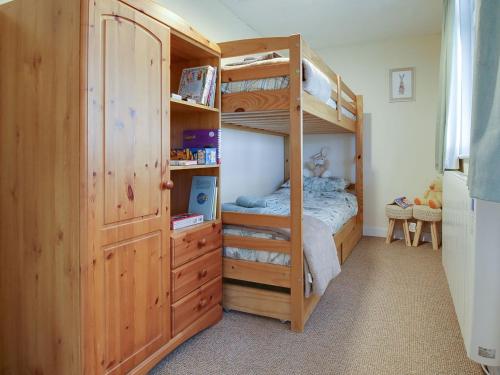 a bedroom with a bunk bed and a bunk bedweredasteryasteryasteryasteryastery at Curlew Cottage in Thorpe Saint Peter