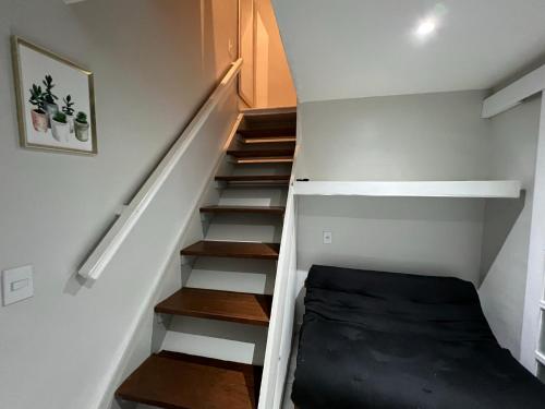 a room with stairs with a bed in it at Studio Apartamento Lindo na Rua das Pedras in Búzios