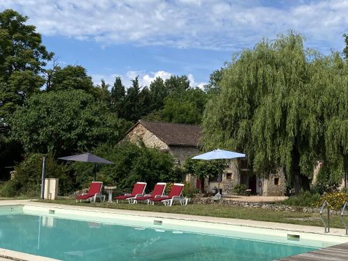 - une piscine avec des chaises et des parasols à côté d'une maison dans l'établissement Sfeervol vakantiehuis op landgoed aan de Dordogne, à Prudhomat