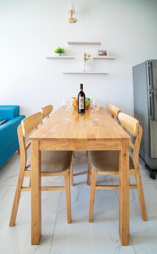 a wooden table with wine glasses and a bottle of wine at Trang Dream House Phan Rang in Kinh Dinh