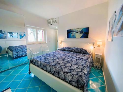 sypialnia z łóżkiem i niebieską podłogą w obiekcie VIP View & Exclusive Access to the Sea w mieście Porto Santo Stefano