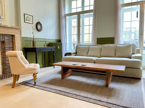 a living room with a couch and a coffee table at Le Petit Malo in Bayeux