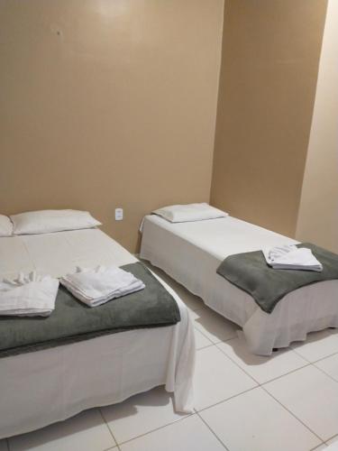 two beds sitting next to each other in a room at Pousada Rota das Dunas de Amaro in Santo Amaro