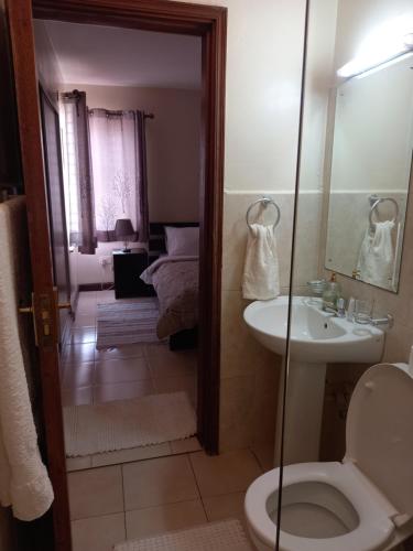 a bathroom with a toilet and a sink at Westpoint Suites by Senga in Nairobi