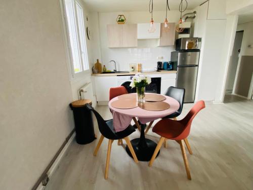 une cuisine avec une table et des chaises dans une cuisine dans l'établissement Superbe appartement centre Montluçon, proche hôpital, à Montluçon