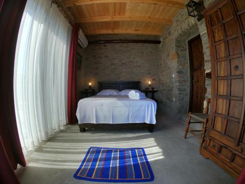 een slaapkamer met een bed en een groot raam bij Hill's Barbacane in Potamós