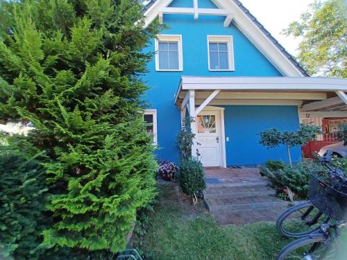 een blauw huis met een fiets voor het huis bij Davids Ferienwohnung in Wustrow