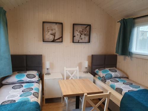 a room with two beds and a table in it at Pokoje Babie Lato in Wrocław