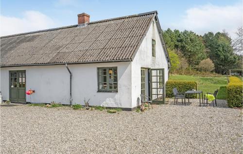 a small white house with a table and chairs at Lovely Apartment In Glesborg With Wifi in Glesborg