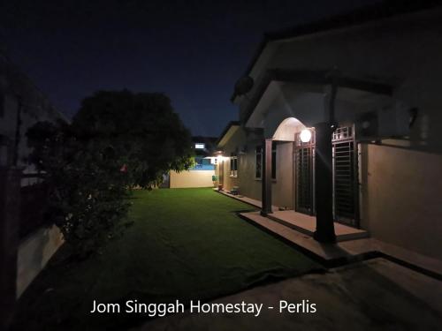 a night view of a house with a green lawn at Jom Singgah Homestay - Perlis in Kangar