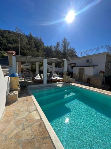 - une piscine d'eau bleue dans la cour dans l'établissement Theodore resort, à Áyios Yeóryios
