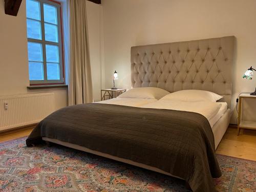 een slaapkamer met een groot bed met een groot hoofdeinde bij Jena The Grand Piano Suite in Jena