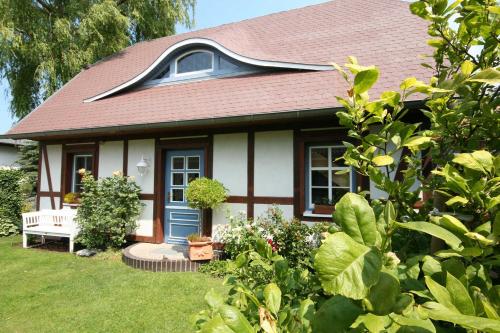 ヴストロにあるFerienhaus Kathrinの青い扉と植物のある小さな家