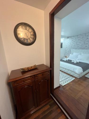 eine Uhr an der Wand neben einem Schlafzimmer in der Unterkunft Timi Residence in Braşov