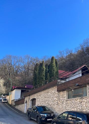 two cars parked in front of a stone building at Timi Residence in Braşov