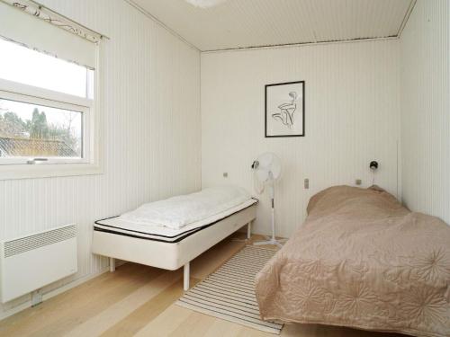 ホルベックにあるHoliday home Holbæk IIIの白いベッドルーム(ベッド1台、窓付)