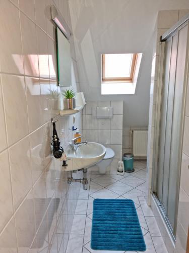 a bathroom with a sink and a shower and a mirror at Windlicht im 1 Stockwerk in Norddeich