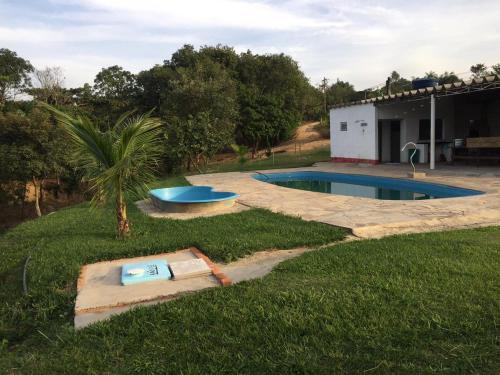 a backyard with a swimming pool and a house at Chalés Pesqueiro Sitio do Aconchego in Pôrto Feliz