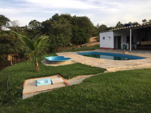 un patio trasero con piscina y una casa en Chalés Pesqueiro Sitio do Aconchego, en Porto Feliz