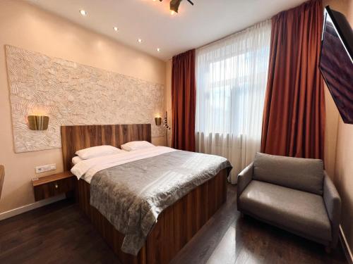 a bedroom with a bed and a chair and a window at Kyiv Panorama Apartments near Gulliver in Kyiv
