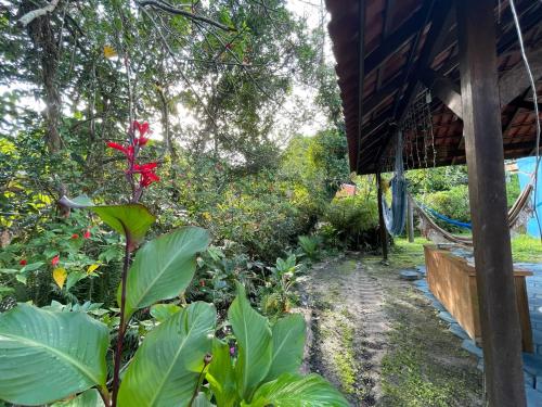 a garden outside of a house with a red flower at Pousada do Ade in Ilha do Mel