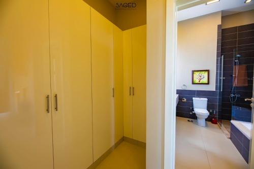 a bathroom with yellow cabinets and a toilet at tawila t1-17 -5 bed room big villa in Hurghada