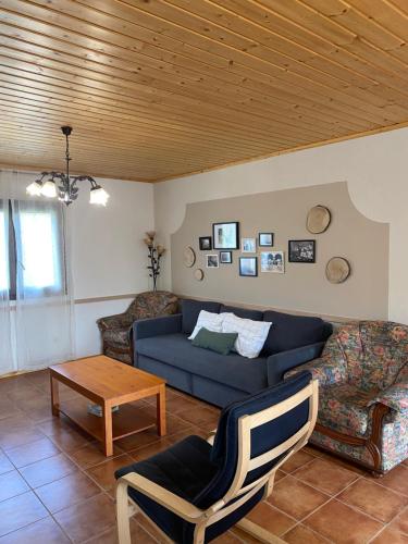uma sala de estar com um sofá azul e cadeiras em Casa Rural Laurenea em Alzate