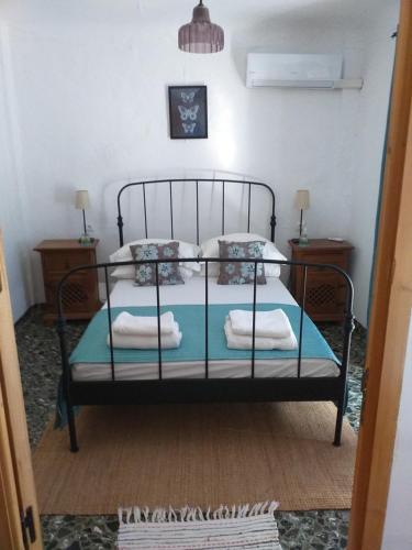 um quarto com uma cama preta com almofadas em Casa Alice em Salar