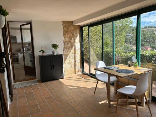 uma cozinha e sala de jantar com mesa e cadeiras em Grand T2 bis avec terrasse et vue em Portel-des-Corbières