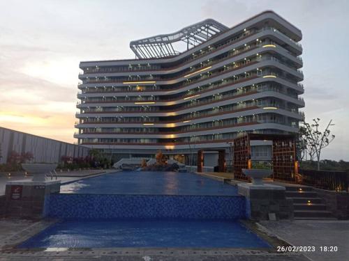 a large building with a pool in front of it at Batam Luxurious, Breezy 1 bedroom! in Nongsa