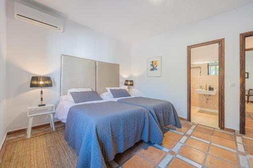 ein Schlafzimmer mit einem Bett mit einer blauen Decke in der Unterkunft BANUS 10 MINUTOS in Estepona