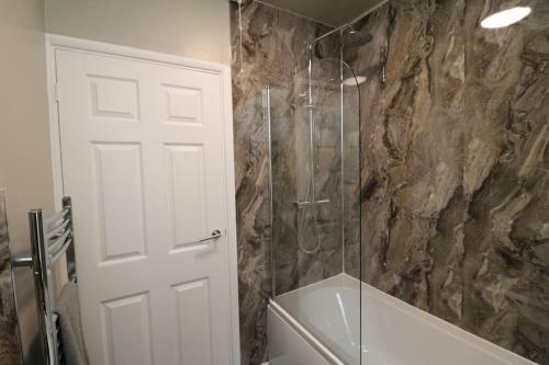 a bathroom with a shower with a glass door at Cosy Two Bedroom Cottage in Whitehaven