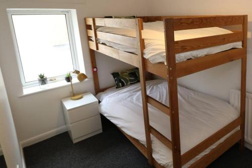 a bedroom with two bunk beds and a window at Cosy Two Bedroom Cottage in Whitehaven