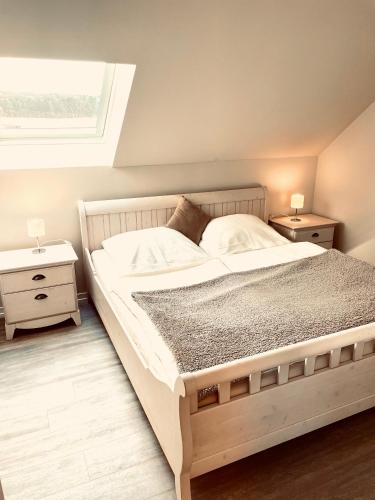 a bedroom with a large white bed with two night stands at Ferienhaus Am Achterwasser in Ueckeritz