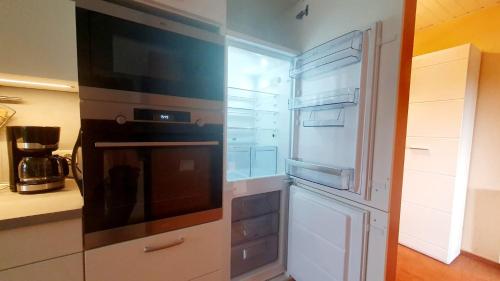 a kitchen with an empty refrigerator and a microwave at Ferienwohnung Im Grünen in Halbendorf