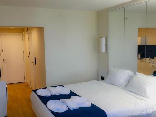 um quarto com uma cama branca e toalhas em Seaside em Batumi
