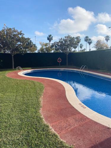 a swimming pool in a yard next to a fence at Dreams Apartment Vilafortuny in Cambrils